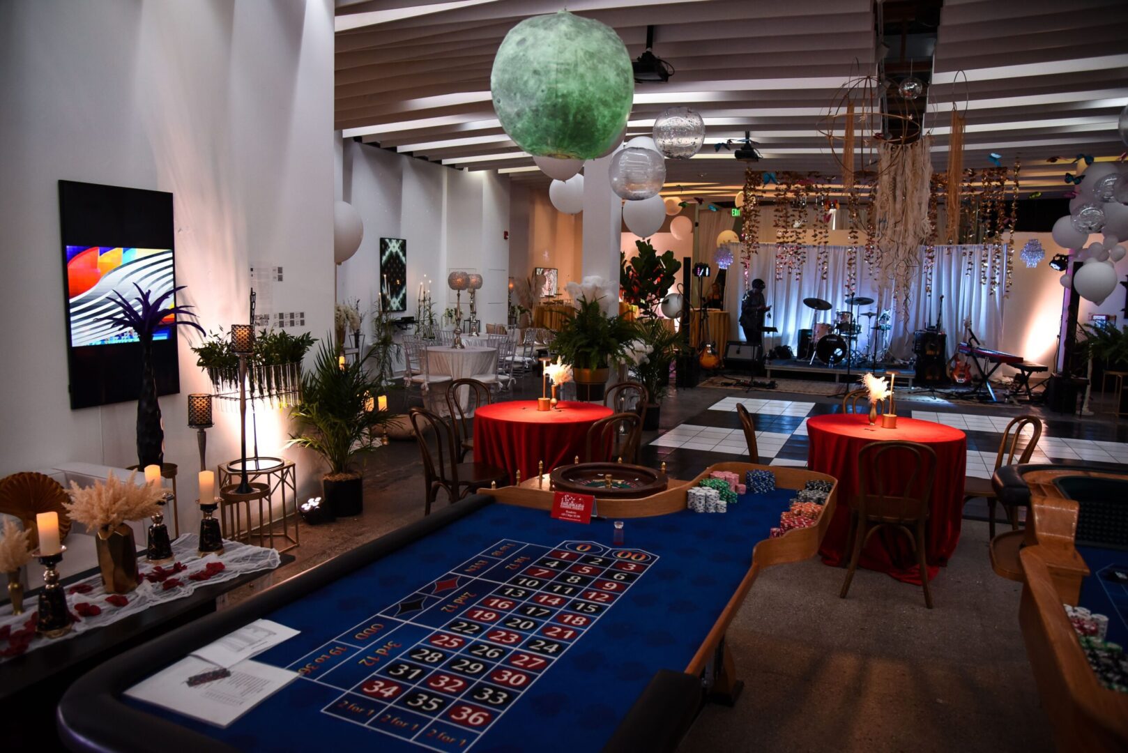 A room with tables and chairs, a table that has been set up for a party.