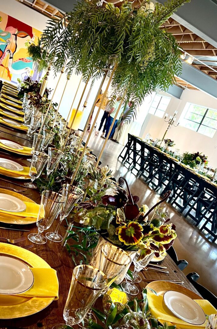 A long table with yellow plates and sunflowers on it.