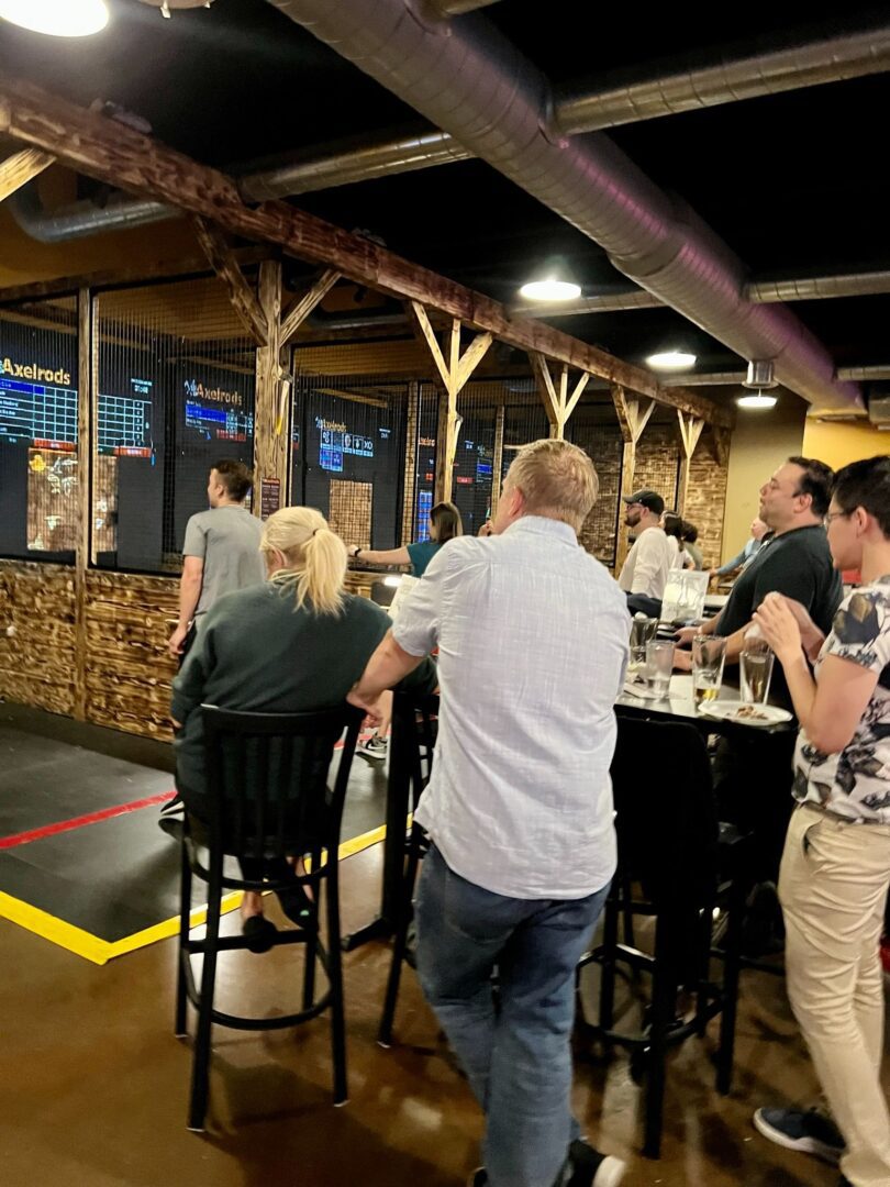 A group of people standing around a bar.