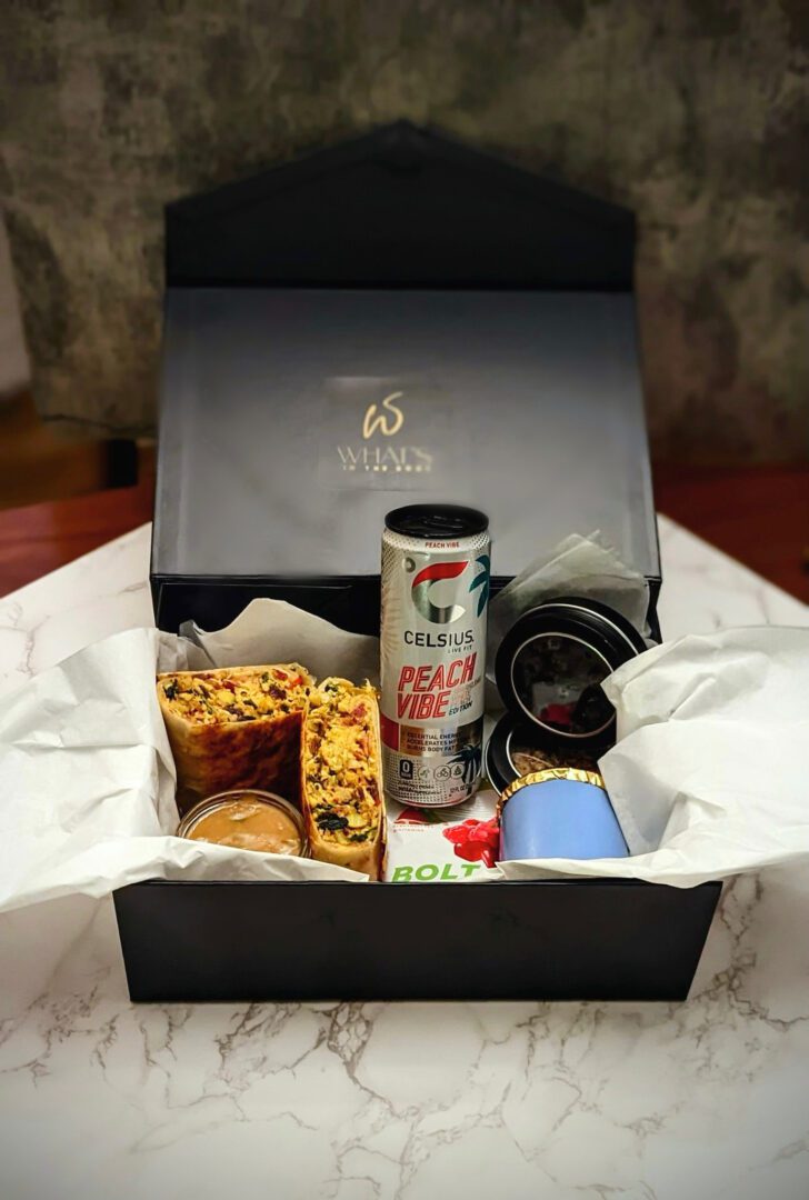 A box of food and drink on top of a table.