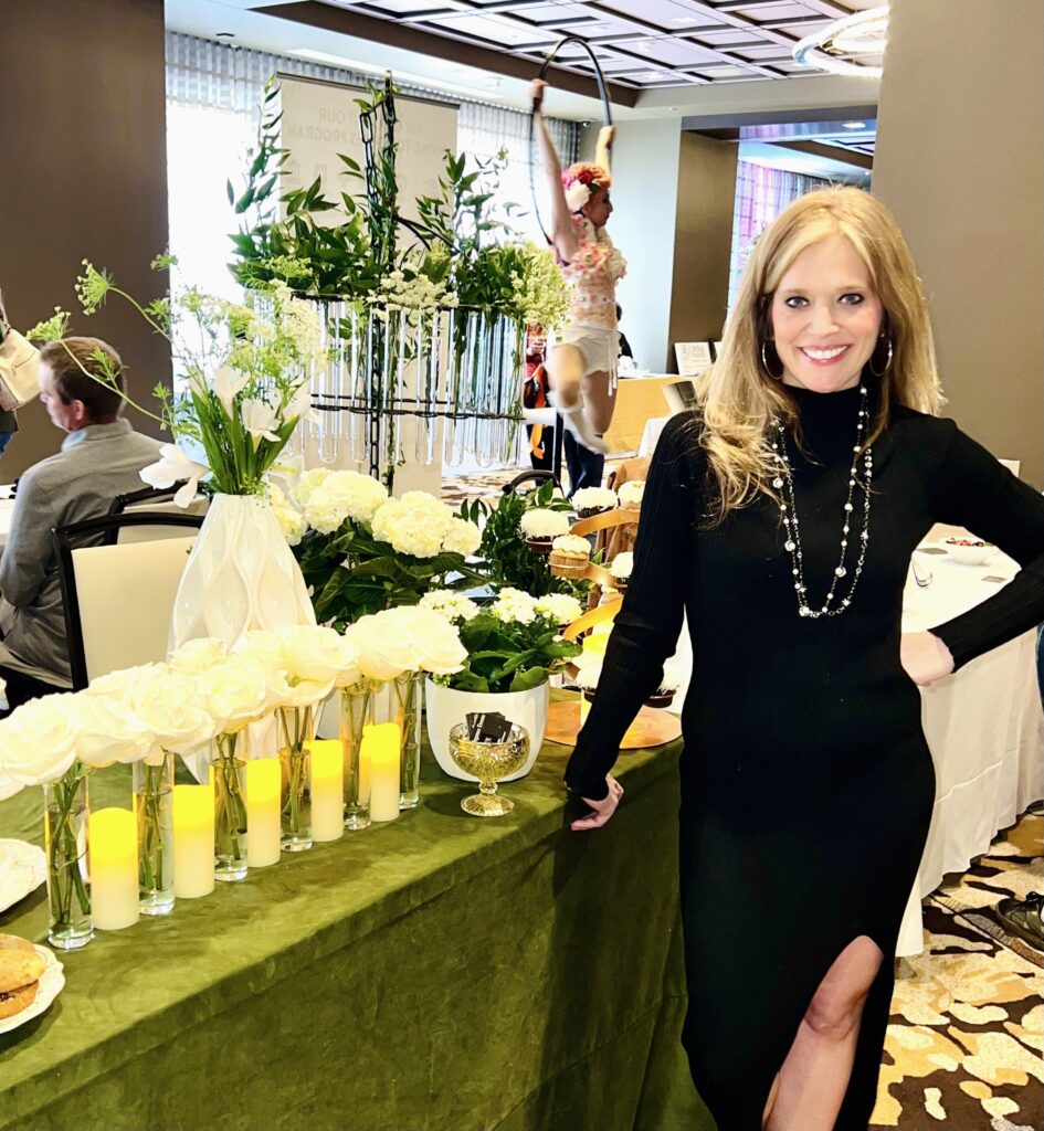 A woman standing next to a table with drinks on it.