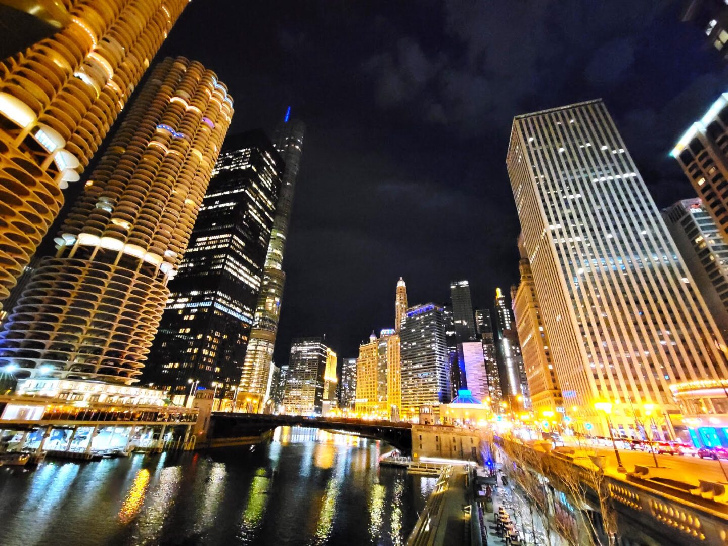 A city skyline with buildings lit up at night.