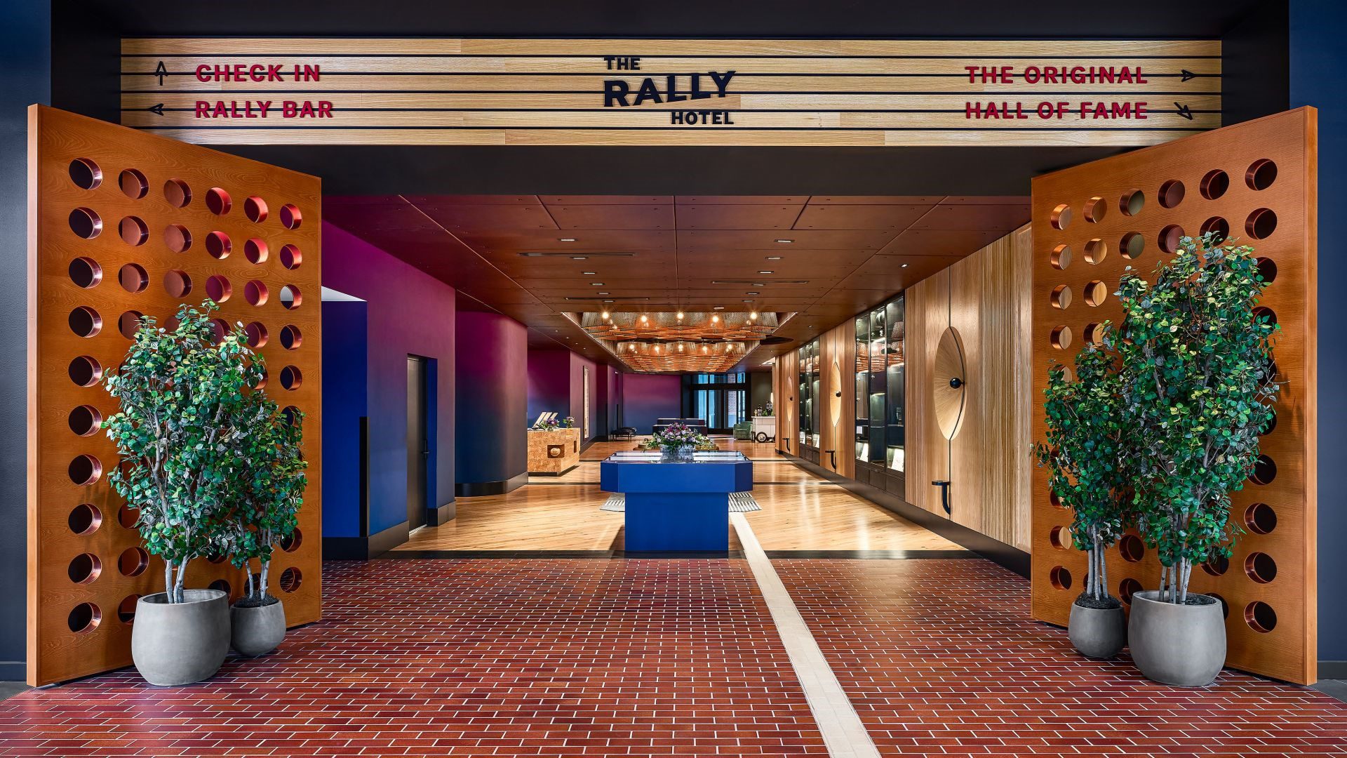 A lobby with a blue carpet and a sign for the rally hotel.