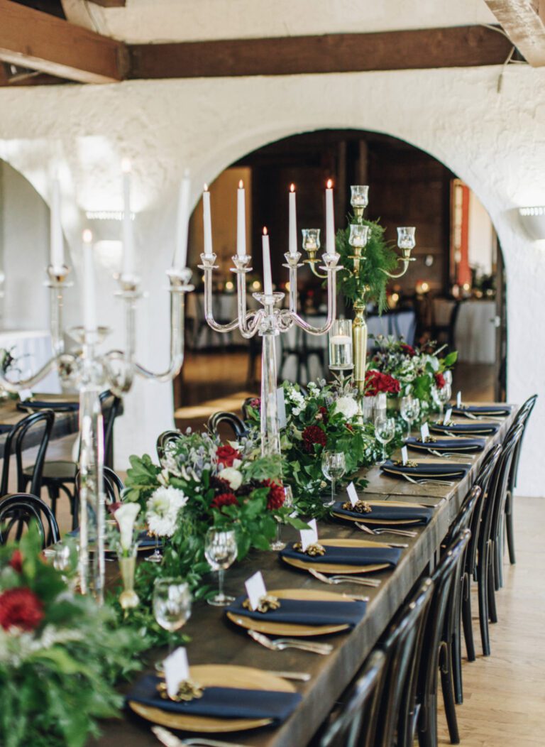 A long table with many candles and flowers on it