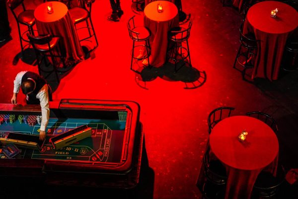 Red-lit room with stools and a pinball machine.