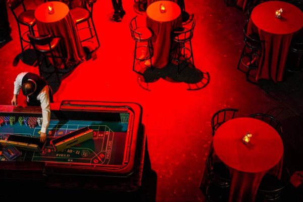 Red-lit room with stools and a pinball machine.