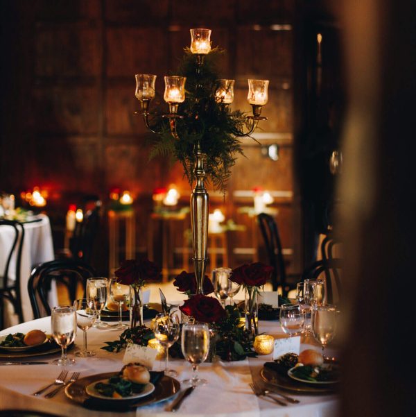 Elegant candlelit dining table set for a special occasion in a warm, intimate ambiance.