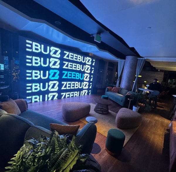 Modern room with a large illuminated ZEBUZ sign and cozy seating.