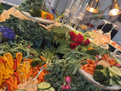 A vibrant display of fresh vegetables like carrots, cucumbers, radishes, and leafy greens.