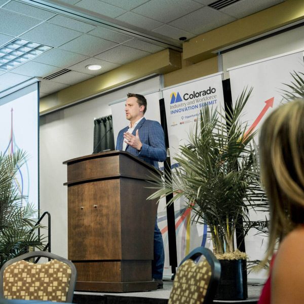 Speaker delivering a presentation at a conference podium.