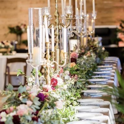 Elegant wedding table setting with floral arrangements and candles.
