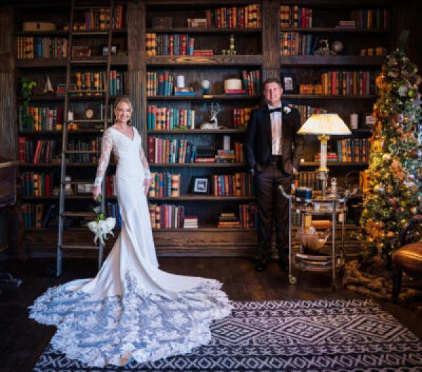 Bride and groom posing elegantly in an vintage library setting.